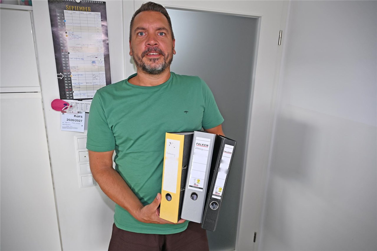 Mann mit drei Ordnern unter dem Arm